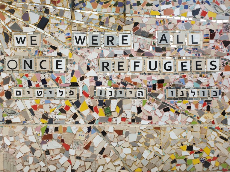 Mur som viser setningen Vi var alle flyktninger en gang. Foto: Antoine Merour, unsplash