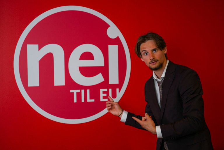 Bilde av Reidar Roll fra Ungdom mot EU som peker på Nei til EU-logoen